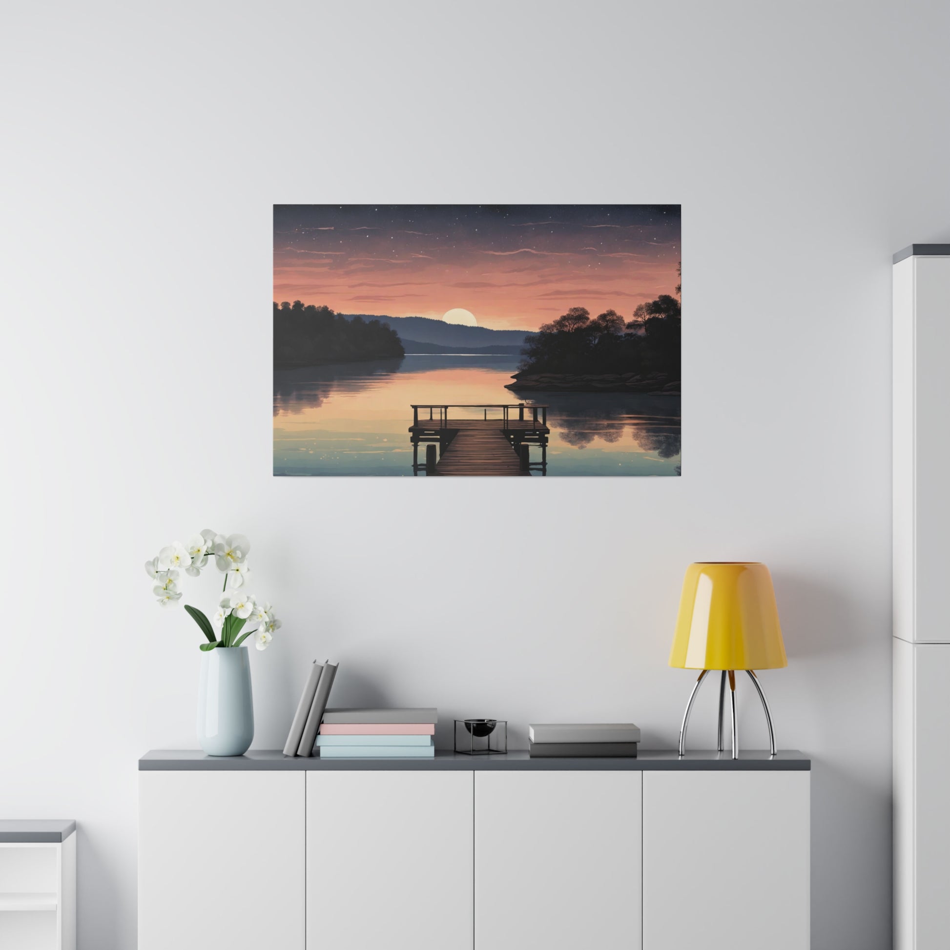 A serene sunset casts warm hues over a smooth lake, with a wooden dock leading into the still water. Stars begin to pepper the dusk sky as the final slice of the sun dips behind a distant tree-lined horizon. Tranquil Serenity Lake Canvas Print