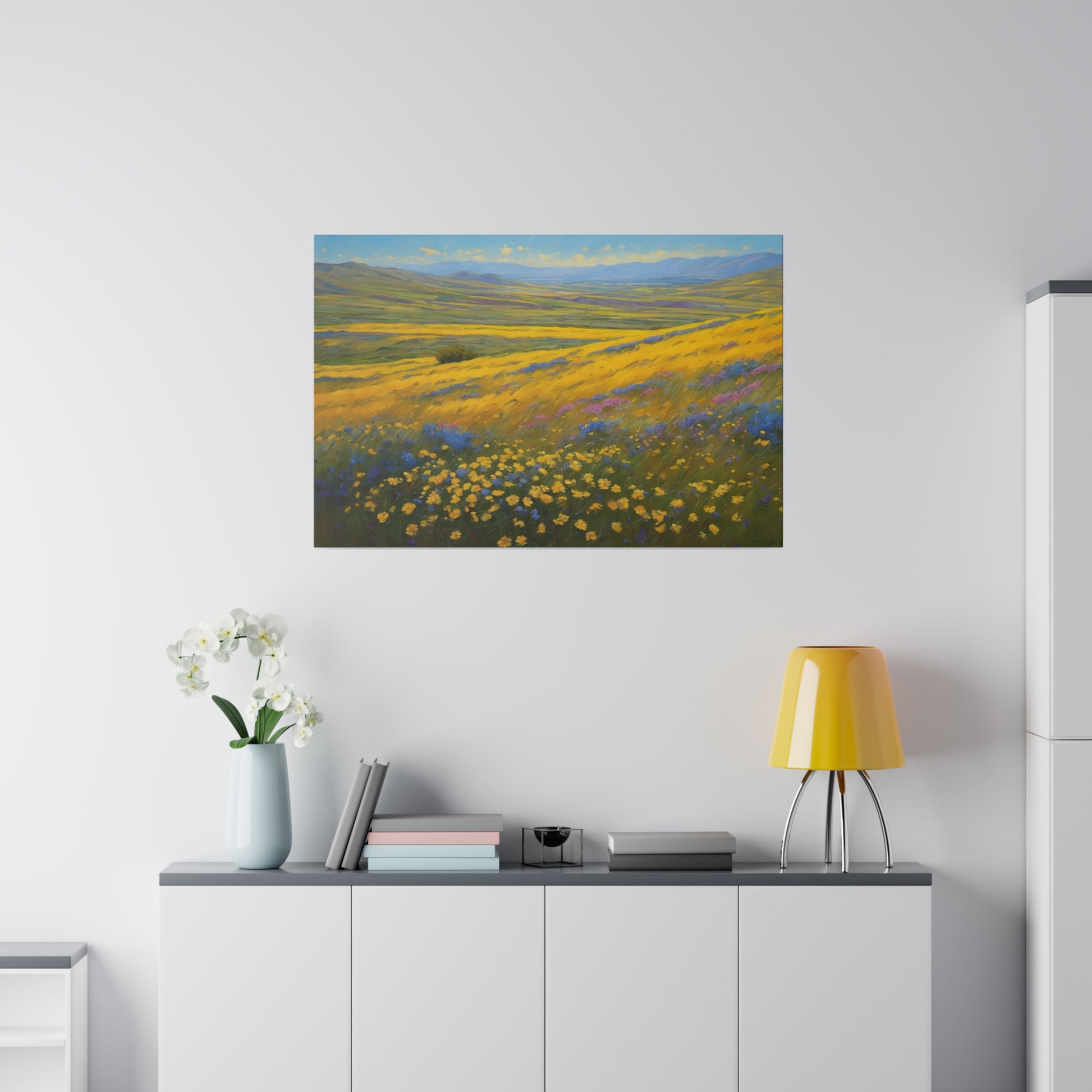 California Carrizo Plain Super Bloom. A vast landscape is covered with vibrant yellow wildflowers, stretching toward rolling hills on the horizon. Blue and purple flowers add a dash of contrasting color against the golden yellow bloom and green grasses swaying under a clear sky.