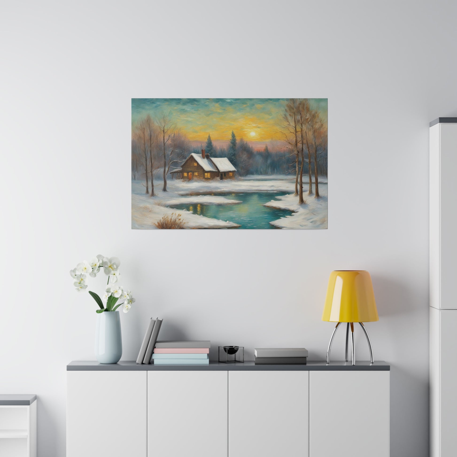 A cozy cabin with a snow-covered roof sits beside a calm, partially frozen pond, surrounded by bare trees and distant evergreen forests under a setting sun. Warm light emanates from the cabin windows, contrasting with the cool tones of the snow and water.